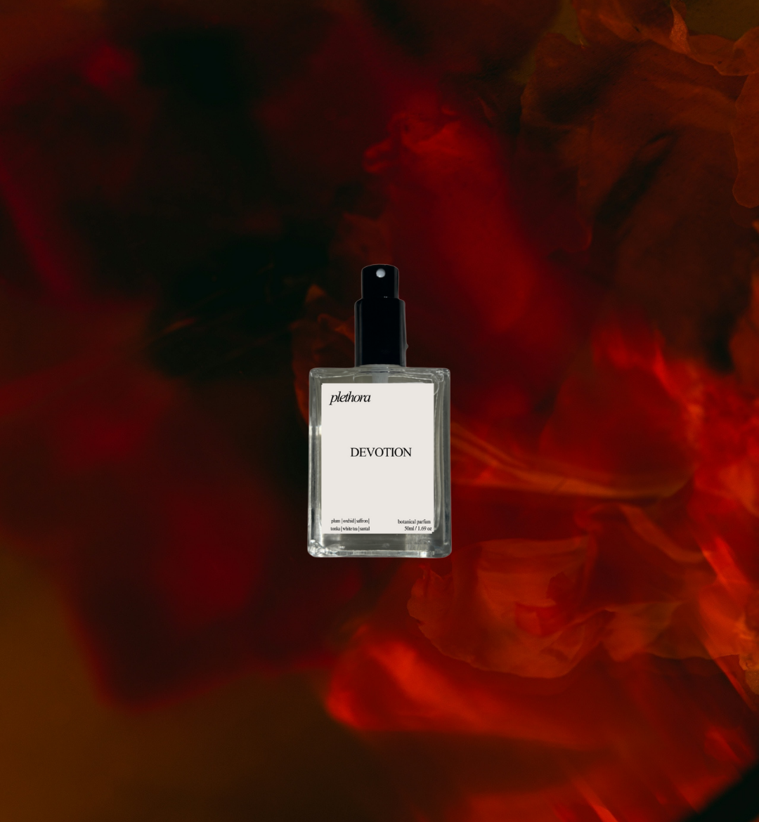 Perfume bottle labeled 'Devotion' with a dark, abstract red and black background